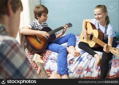 Children In Bedroom Playing Guitars Together