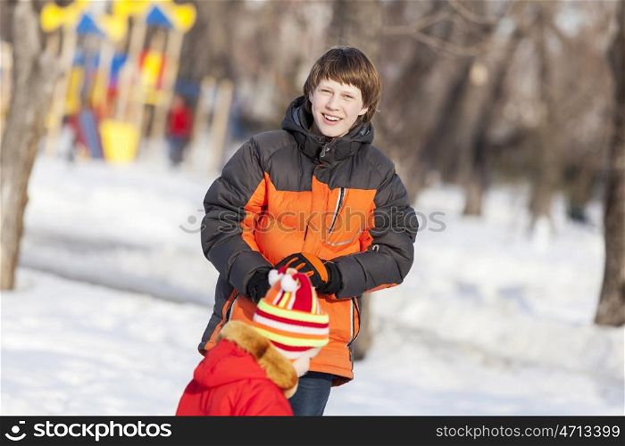 Children in winter park having fun and playing snowballs. Winter activities