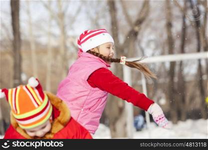 Children in winter park having fun and playing snowballs. Winter activities