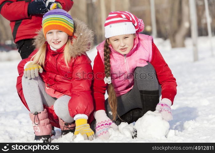 Children in winter park having fun and playing snowballs. Winter activities