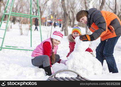 Children in winter park having fun and playing snowballs. Winter activities