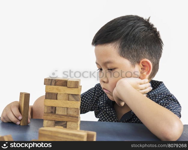 Children is playing jenga, a wood blocks tower game for practicing tChildren is playing jenga, a wood blocks tower game for practicing their physical and mental skAsian kid is boring a wood block tower game, feeling sad and disappointed with the gameillheir physical and mental skill
