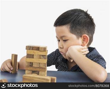 Children is playing jenga, a wood blocks tower game for practicing tChildren is playing jenga, a wood blocks tower game for practicing their physical and mental skAsian kid is boring a wood block tower game, feeling sad and disappointed with the gameillheir physical and mental skill