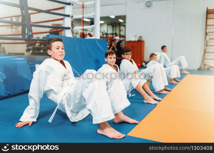 Children judo, kids in kimono practice martial art in hall. Little boys and girls in uniform on sport training