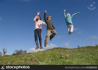 Children jumping on hill