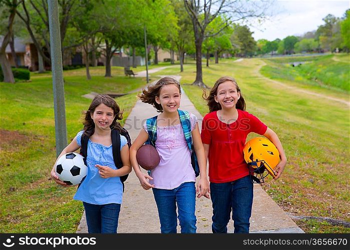 Children kid girls walking to schoool with sport balls folders and backpacks in outdoor park