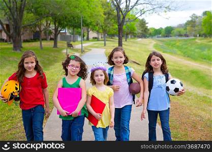 Children kid girls walking to schoool with sport balls folders and backpacks in outdoor park
