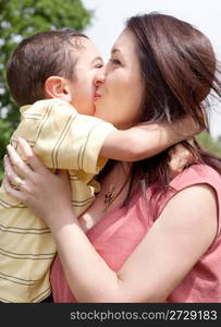 Children kissing his mom in a park,outdoor