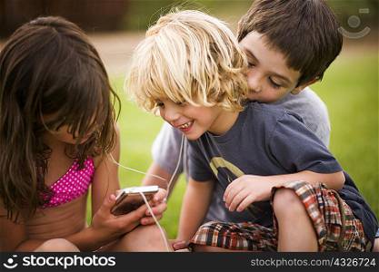Children listening to earphones outdoors