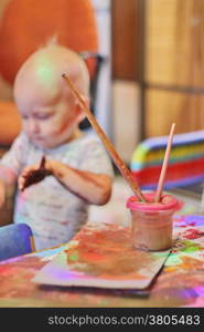 Children little boy draws with colored inks