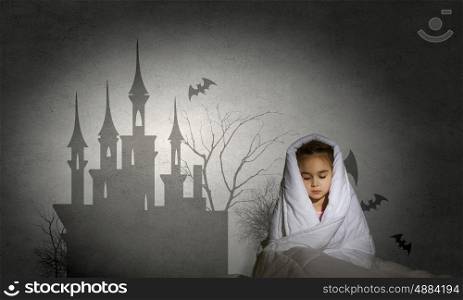 Children nightmare. Cute scared girl sitting in bed under blanket