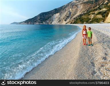 Children on beach. Sea evening view ( Myrtos Beach, Greece, Kefalonia, Ionian Sea).