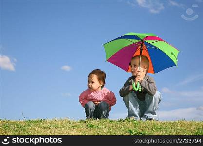children on meadow with umbrella