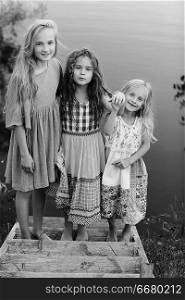 children on the riverbank / summer vacation merry girlfriends on vacation, sisters together on the river, friendship happiness family