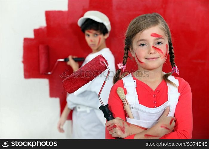 Children painting a wall red