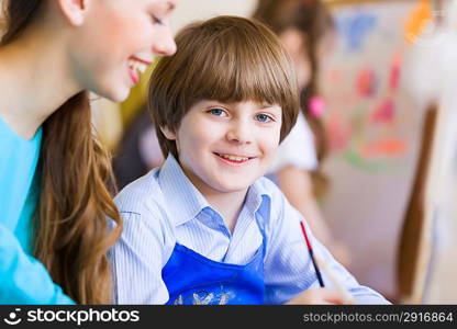 Children painting with teacher