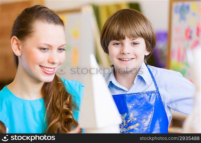 Children painting with teacher