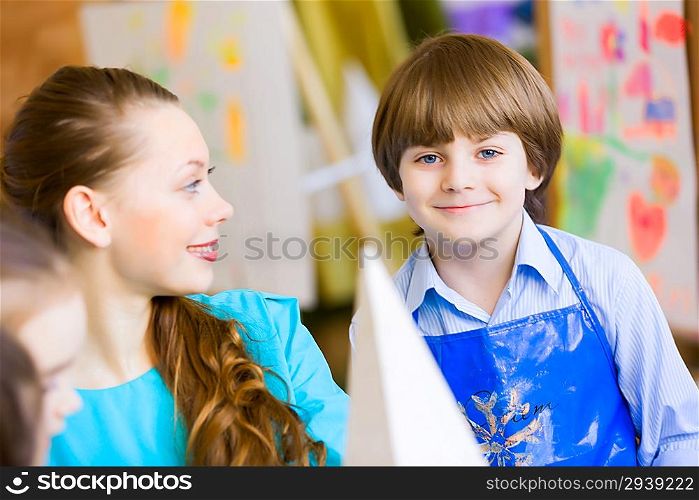 Children painting with teacher