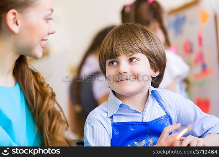 Children painting with teacher