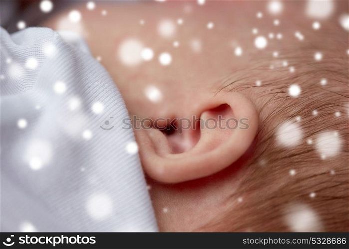 children, people and care concept - close up of baby ear over snow. close up of baby ear