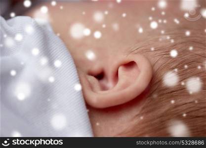 children, people and care concept - close up of baby ear over snow. close up of baby ear