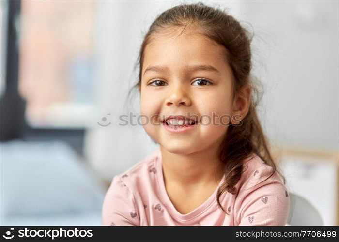 children, people and childhood concept - portrait of happy smiling little girl at home. portrait of happy smiling little girl at home