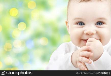 children, people, infancy and age concept - beautiful happy baby over green lights background