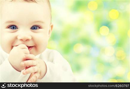 children, people, infancy and age concept - beautiful happy baby over green lights background