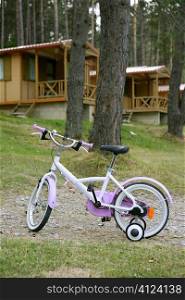 Children pink bicycle in wooden cabin mountain pine camping Pyrenees