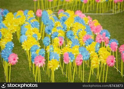 Children pinwheels on grass. Yellow, blue and red pinwheels on a meadow
