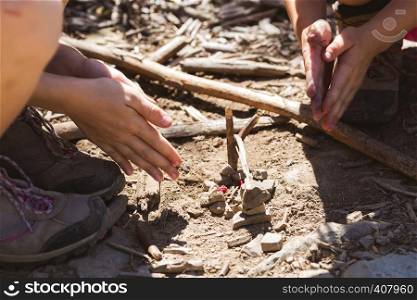 children play on a hike - warm their hands around an improvised campfire