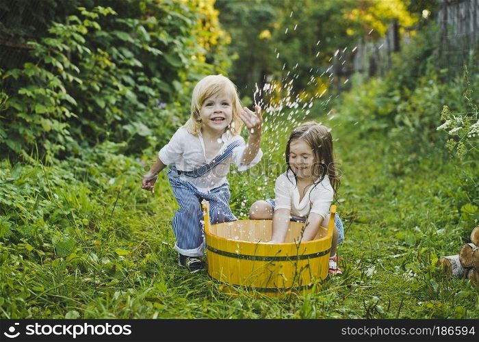 Children play with water in the garden.. Children splashing water in the basin 4755.