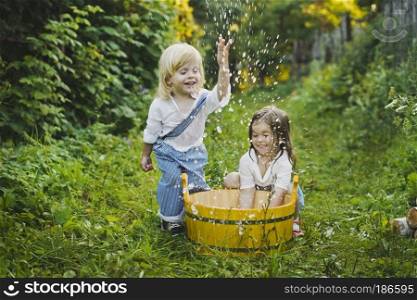 Children play with water in the garden.. Children splashing water in the basin 4756.