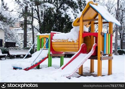 Children playground empty in the snow .