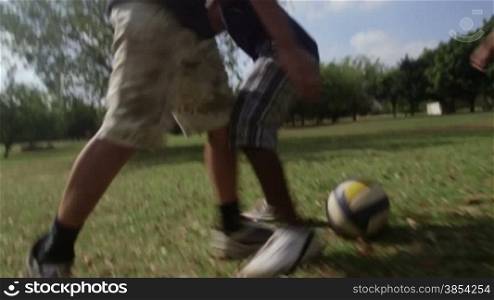 Children playing football match, group of young kids having fun with soccer game in park. Sequence, low angle view