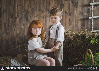 Children playing holding hands.. Children holding hands on the background of wooden walls and hay 6085.