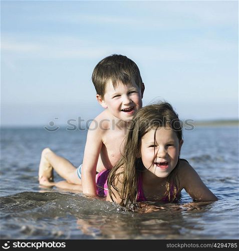 Children playing in waves on beach