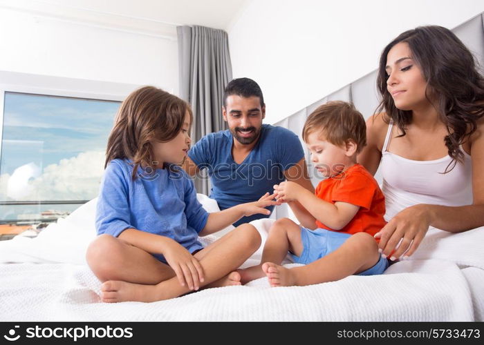 Children playing on parents bed wearing pajamas