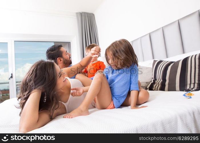 Children playing on parents bed wearing pajamas