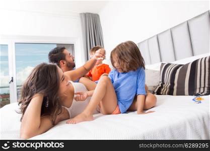 Children playing on parents bed wearing pajamas