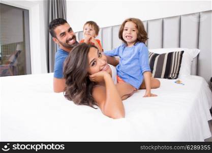 Children playing on parents bed wearing pajamas
