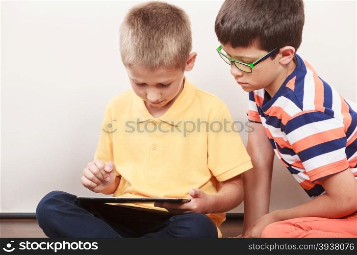 Children playing on tablet. Having fun and learning