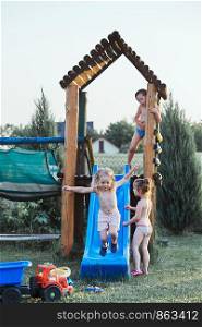Children playing together in a playground during hot summer vacation day. Candid people, real moments, authentic situations
