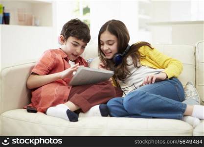 Children Playing With Digital Tablet And MP3 Player