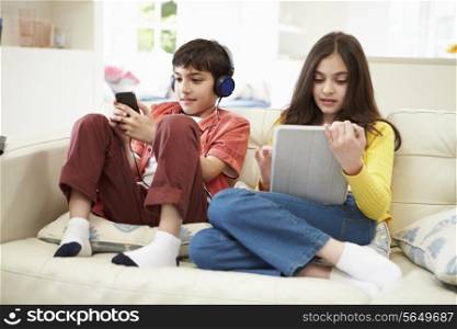 Children Playing With Digital Tablet And MP3 Player
