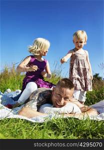 Children playing with father outdoors