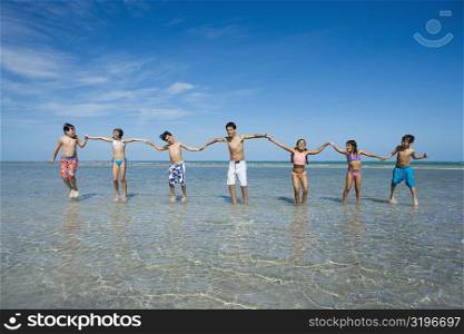 Children playing with holding each other hands on the beach
