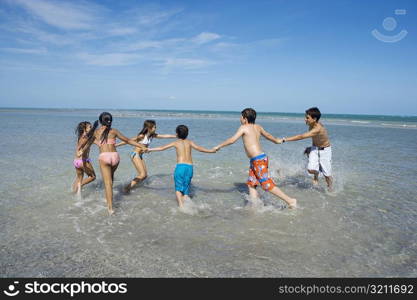 Children playing with holding each other hands on the beach