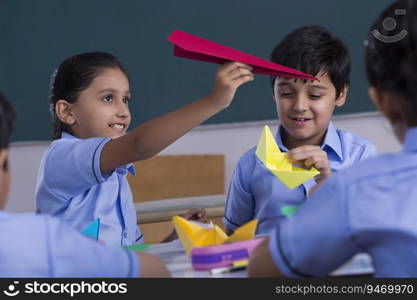 children playing with paper plane and boat in class