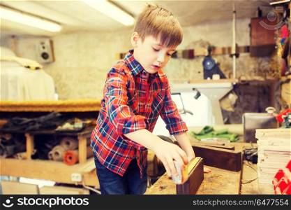 children, profession, carpentry, woodwork and people concept - happy little boy with ruler measuring wood plank at workshop. happy little boy with plank and ruler at workshop. happy little boy with plank and ruler at workshop